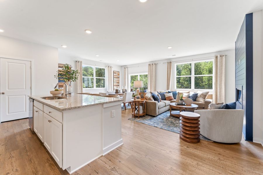 A large living room with a large kitchen island. A large living room with a large kitchen island.