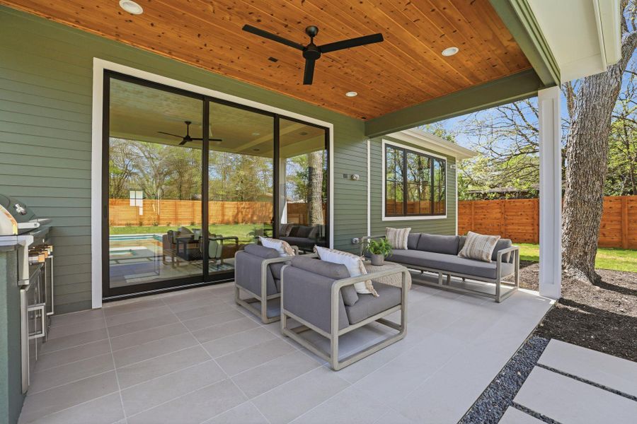 Fenced backyard featuring an outdoor hangout area, a patio, and ceiling fan
