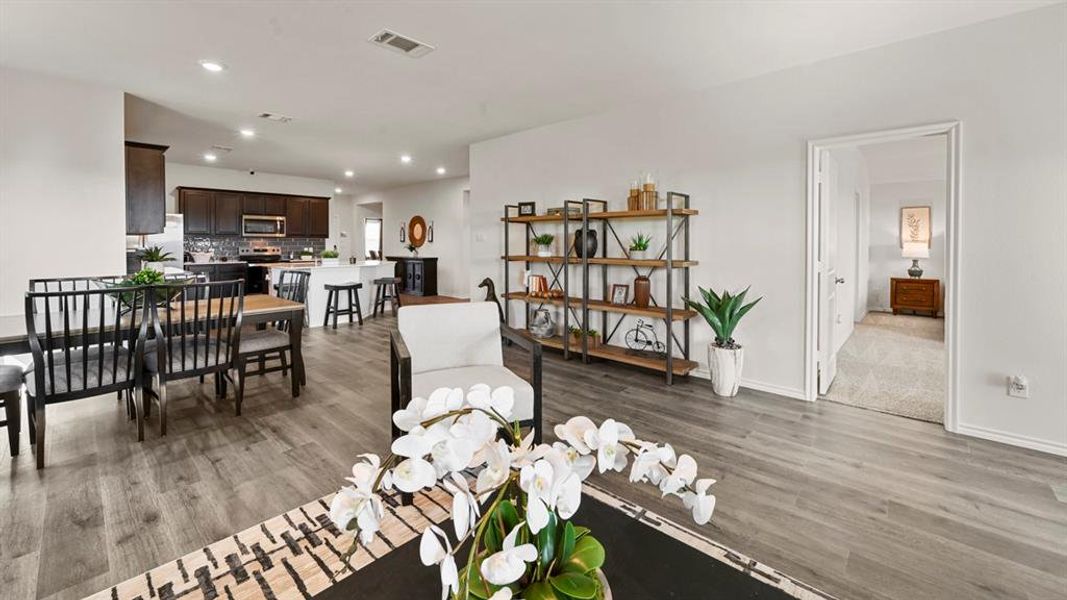 The property features light gray wood-style flooring, white walls, and recessed lighting throughout