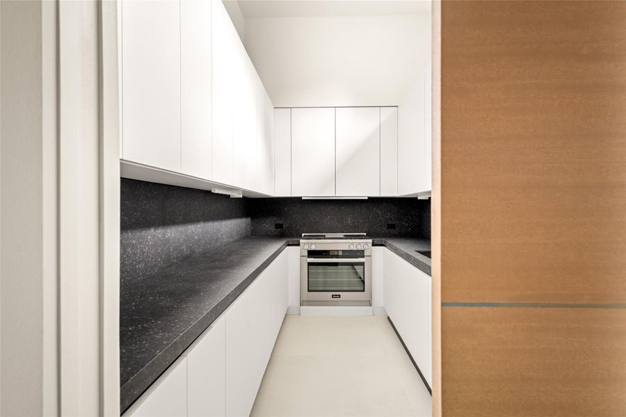 Fully outfitted scullery offering generous prep space, sleek cabinetry, and added functionality for entertaining.