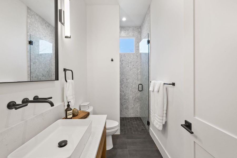 Full bath with a stall shower, vanity, dark tile patterned floors, and recessed lighting