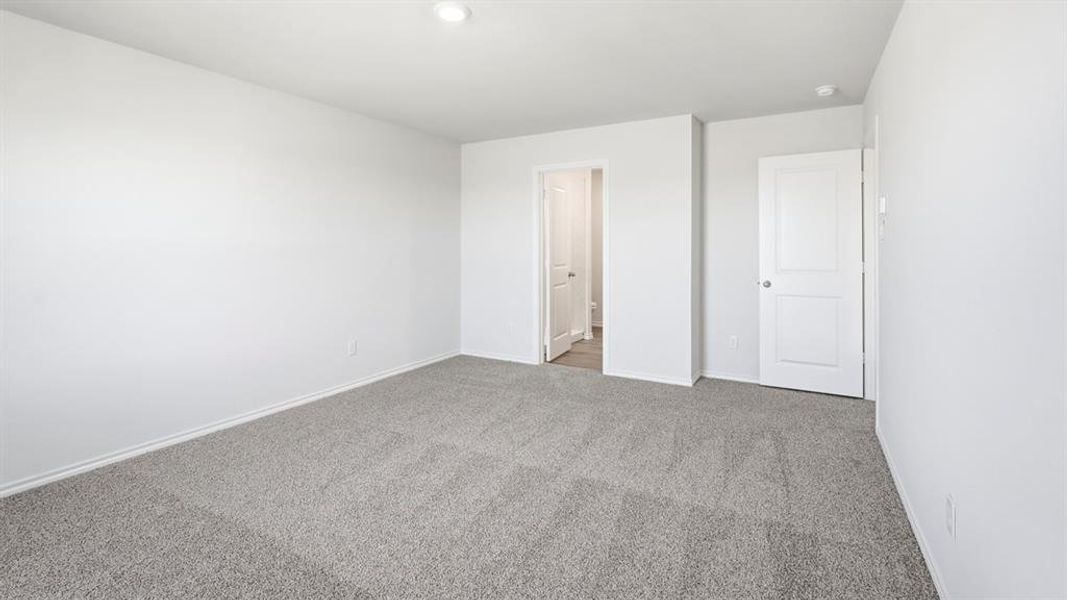 Unfurnished bedroom featuring light carpet and baseboards