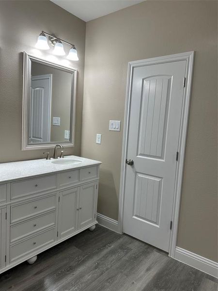 Bathroom with wood finished floors, vanity, and baseboards