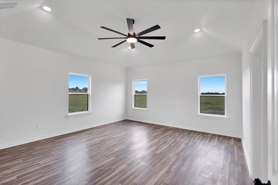 The room features vaulted ceilings, recessed lighting, and a modern ceiling fan