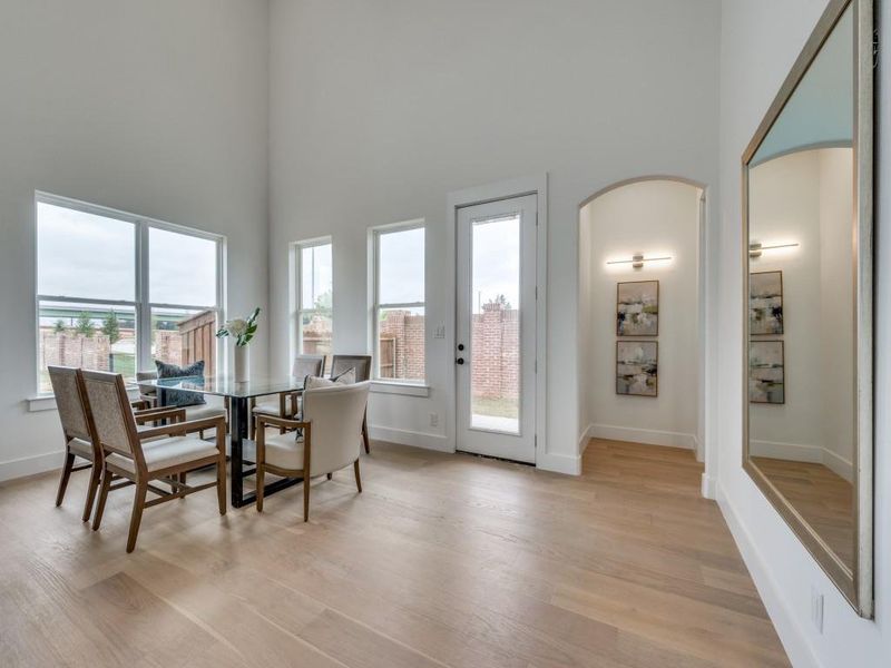 Dining space with a high ceiling and light hardwood / wood-style flooring