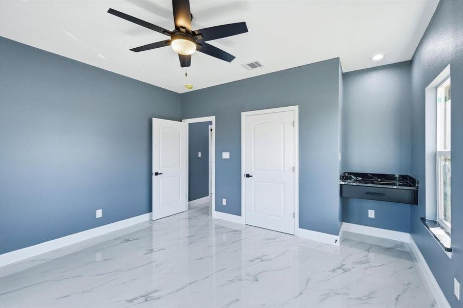 Unfurnished bedroom with light marble finish floors, a ceiling fan, and recessed lighting