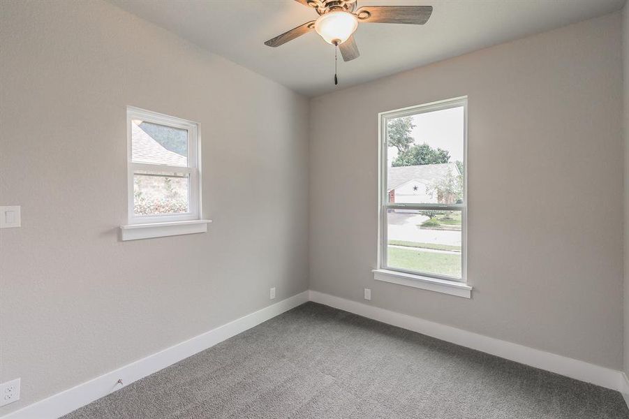 Carpeted empty room with ceiling fan