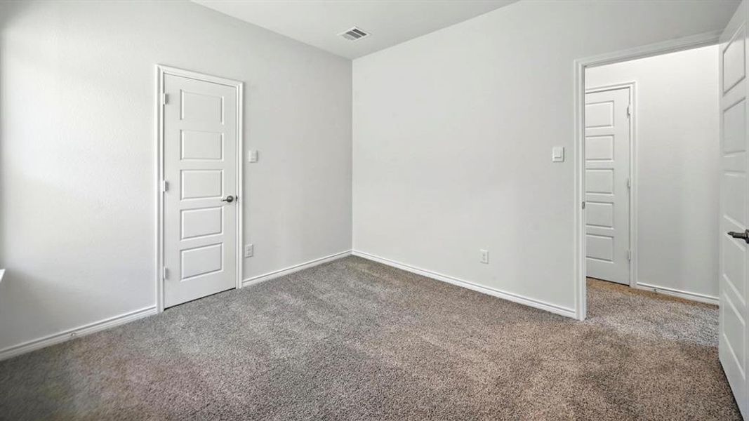 Carpeted empty room with baseboards