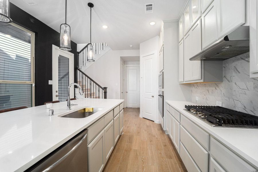 Expansive island with seating, pendant lighting, and abundant storage.