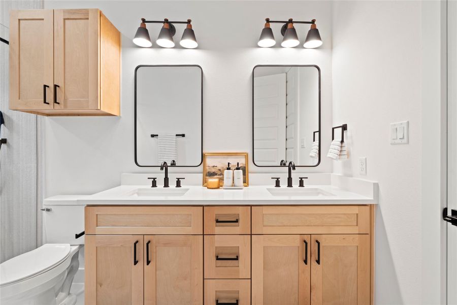 Perfectly balanced and beautifully styled, the dual-sink vanity in the primary ensuite offers generous storage, designer lighting, and minimalist sophistication.