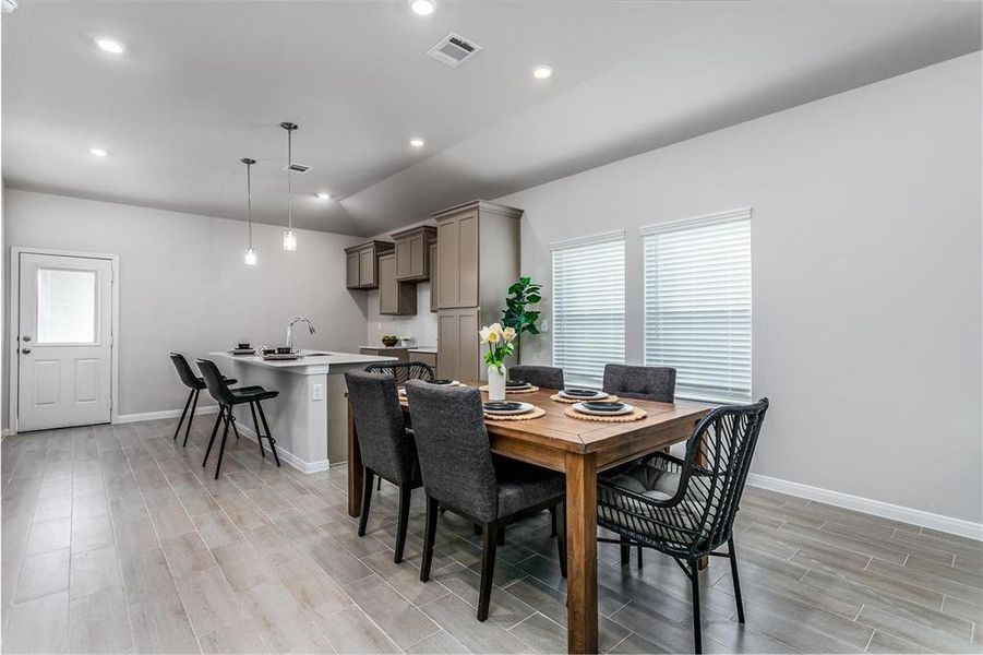 The open-concept dining area is perfectly situated next to the kitchen, providing an ideal space for family meals and gatherings. With large windows inviting ample natural light, this area combines comfort with modern elegance, creating a welcoming environment for both everyday living and entertaining. **This image is from another Saratoga Home - Mockingbird floorplan.**