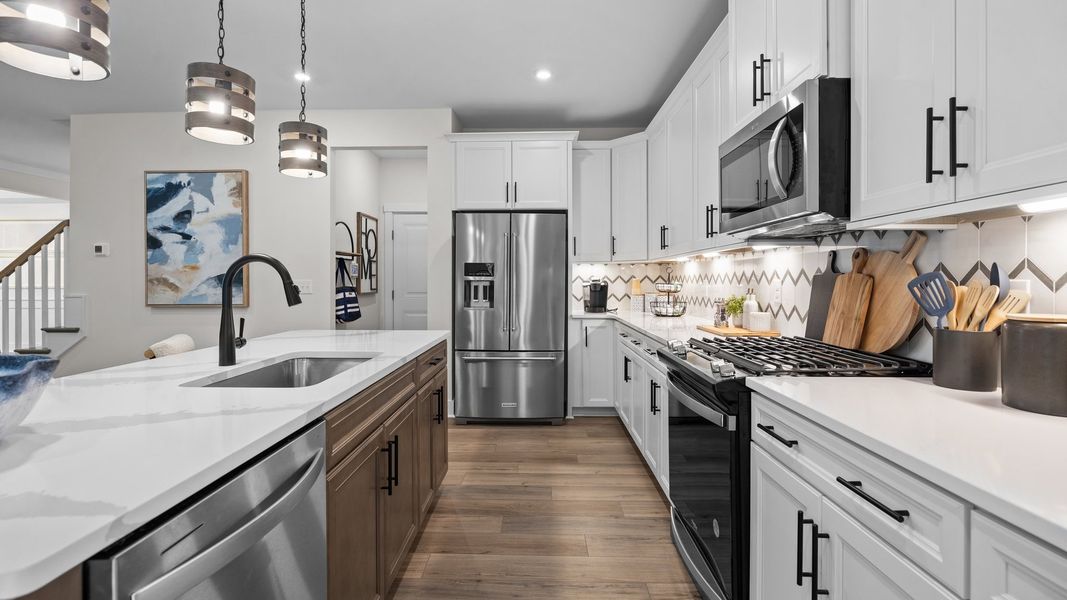 Kitchen with premium cabinets, elegant quartz countertops, and pendant lighting in the Jordan Design by DRB Homes in York, SC