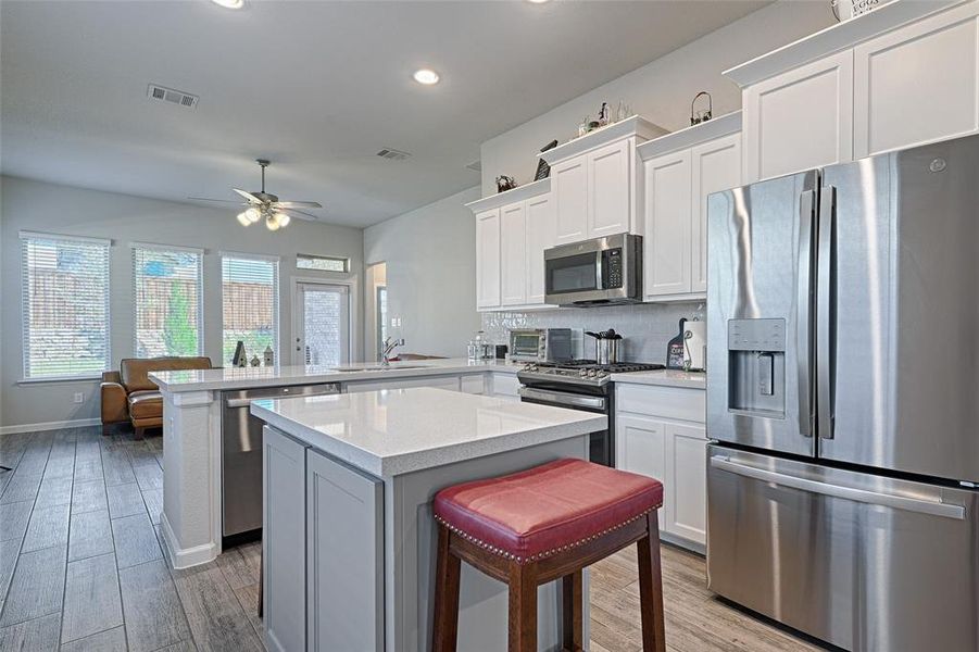 Kitchen with a breakfast bar, a kitchen island, and stainless steel appliances