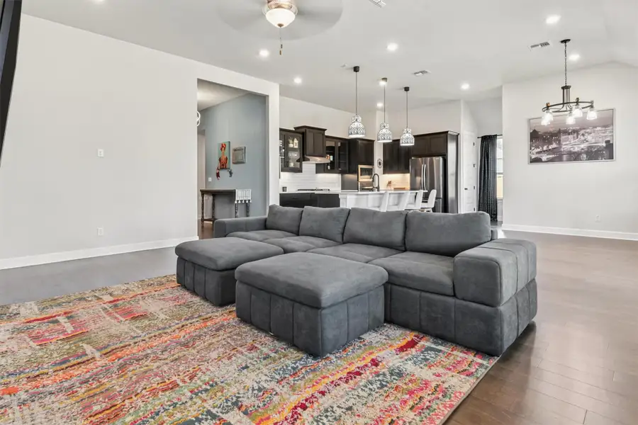 Living room featuring wood finished floors, recessed lighting, a ceiling fan, and vaulted ceiling Living room featuring wood finished floors, recessed lighting, a ceiling fan, and vaulted ceiling