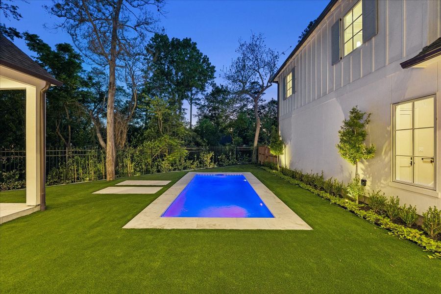 Heated pool with Hayward automated controls for lights & fountain, surrounded by turf  and landscaped borders. Fenced yard enhanced with landscape lighting, recently added drainage & drain boxes for water flow functionality.