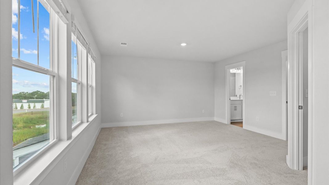 Eye-catching details and elegant finishes in the vibrant primary suite of this select home