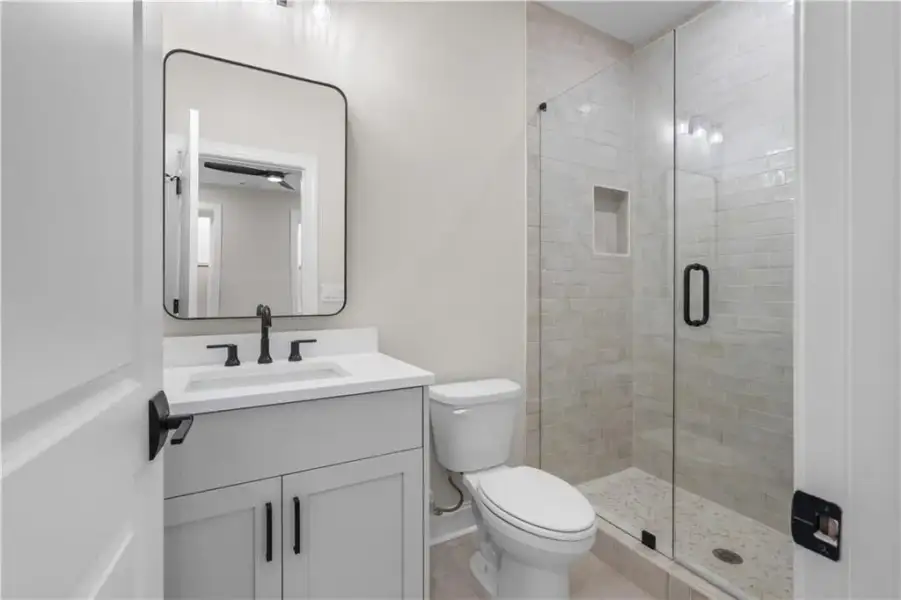 Contemporary quartz vanity with matte black fixtures and a rectangular basin, enjoy a beautifully finished tiled shower to the ceiling with frameless shower enclosure!