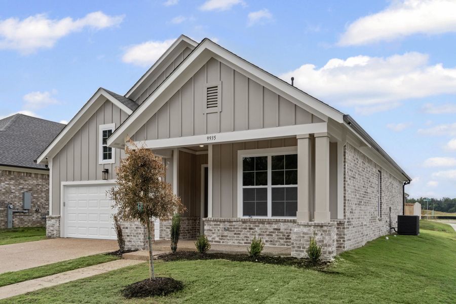 View of front of property featuring board and batten siding, covered porch, and a front lawn