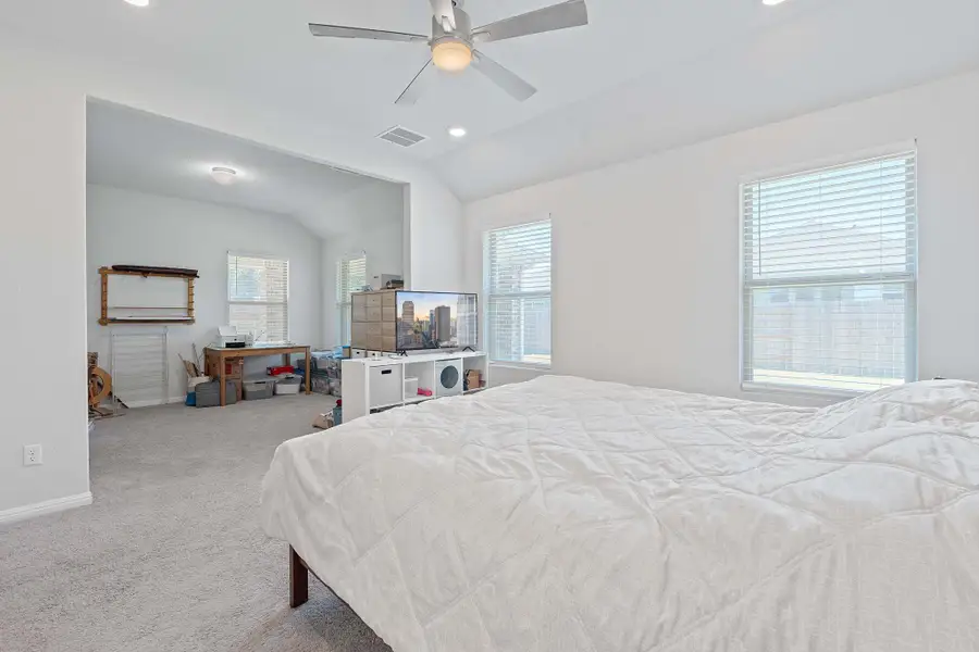 Bedroom with carpet floors, vaulted ceiling, recessed lighting, and a ceiling fan Bedroom with carpet floors, vaulted ceiling, recessed lighting, and a ceiling fan