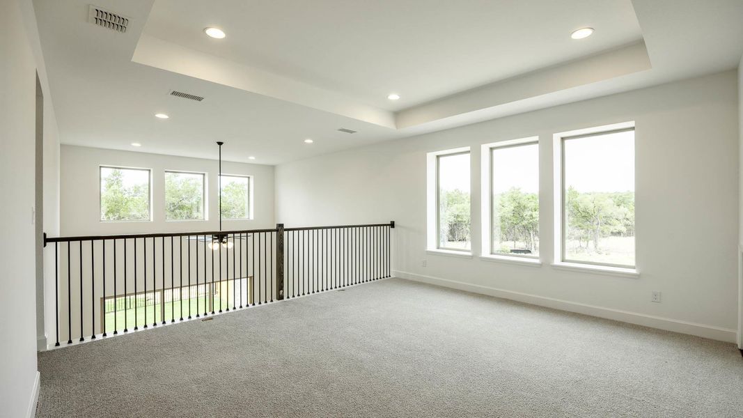 Carpeted empty room with a tray ceiling and recessed lighting Carpeted empty room with a tray ceiling and recessed lighting