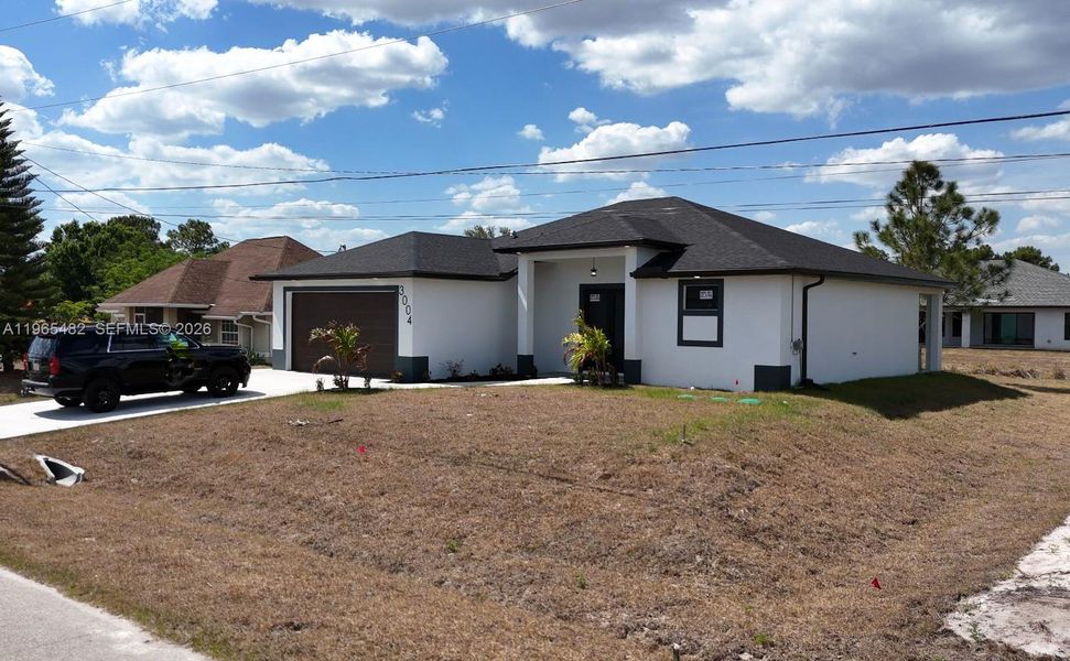 Front exterior of a new home in , Lehigh Acres, FL, highlighting curb appeal (Image 21).