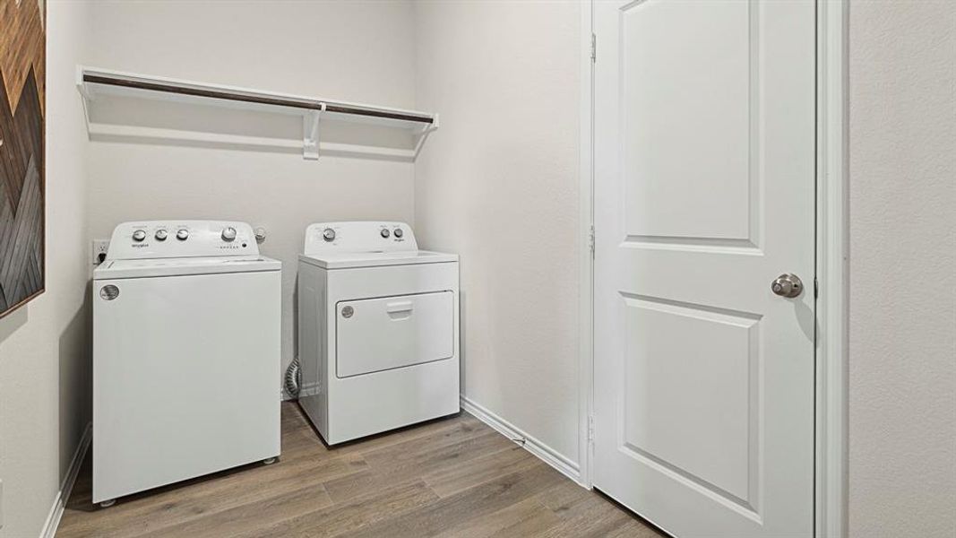 Laundry area featuring a top-load washing machine, a front-load dryer, and a wall-mounted shelf with a hanging rod