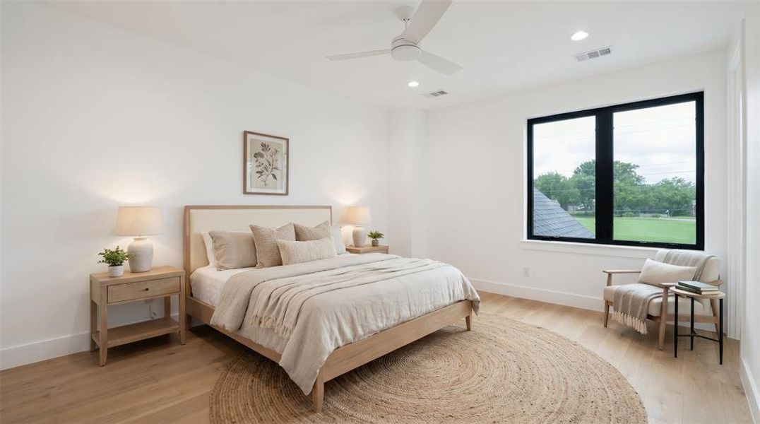 Spacious room with light wood-finish flooring, recessed lighting, and a modern ceiling fan