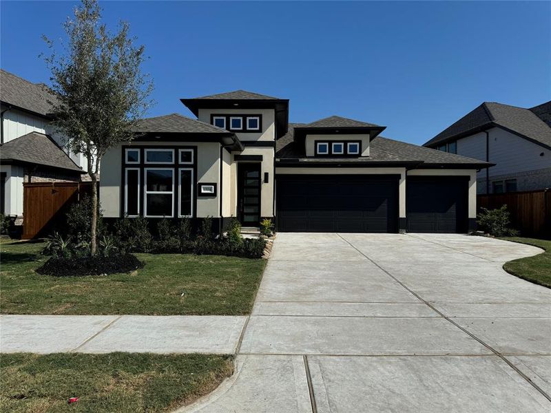 Elegant modern elevation with striking colors and a full 3 car garage.