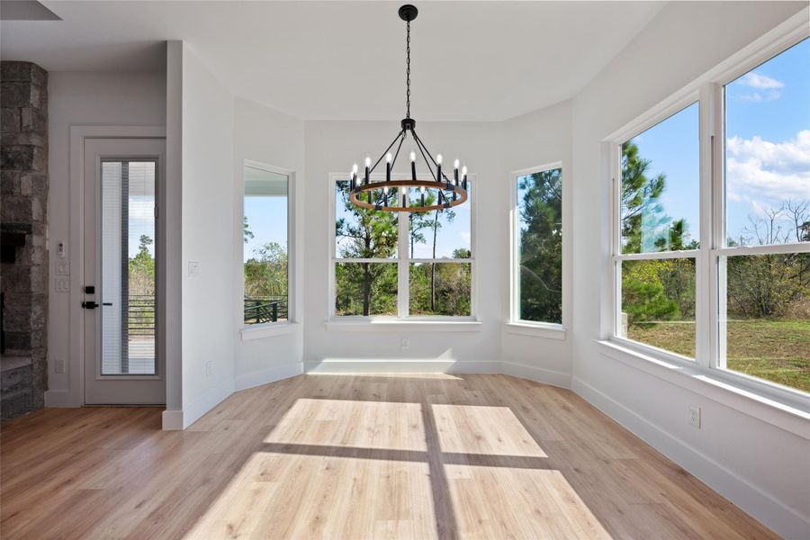 Unfurnished sunroom with wood finished floors and a chandelier