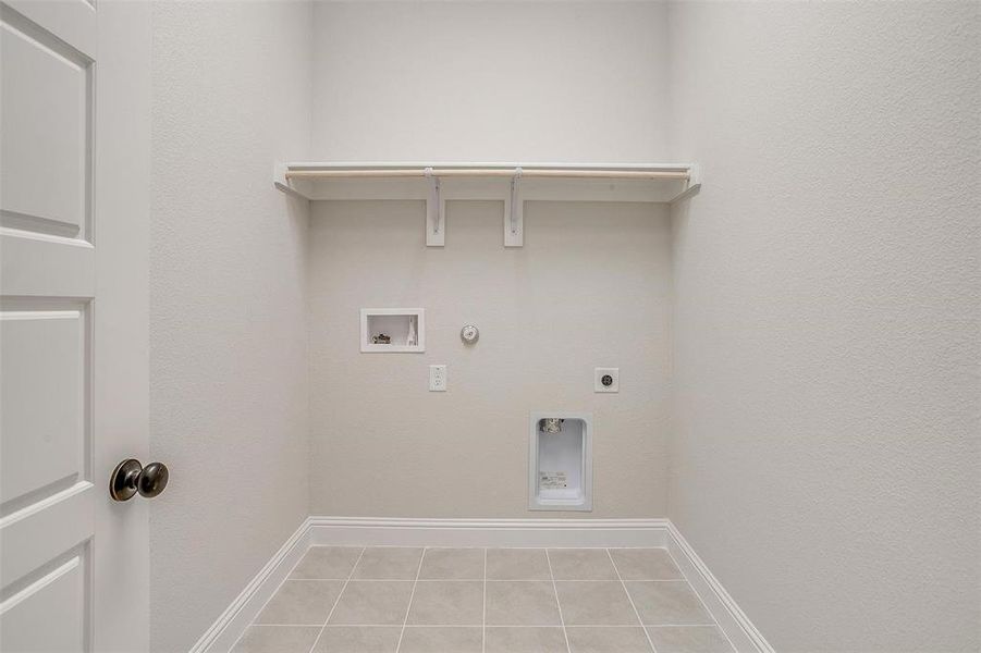 Laundry room featuring hookup for an electric dryer, gas dryer hookup, light tile patterned floors, and washer hookup