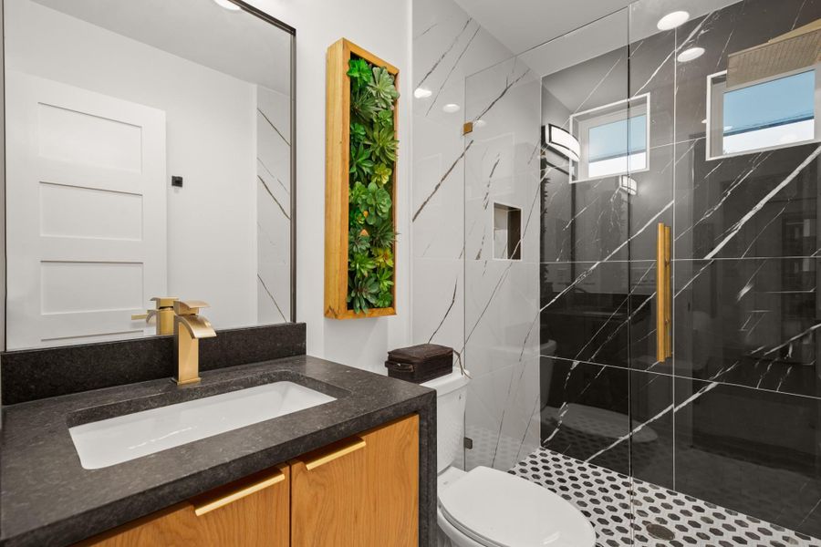 Full bathroom featuring vanity, a marble finish shower, and recessed lighting