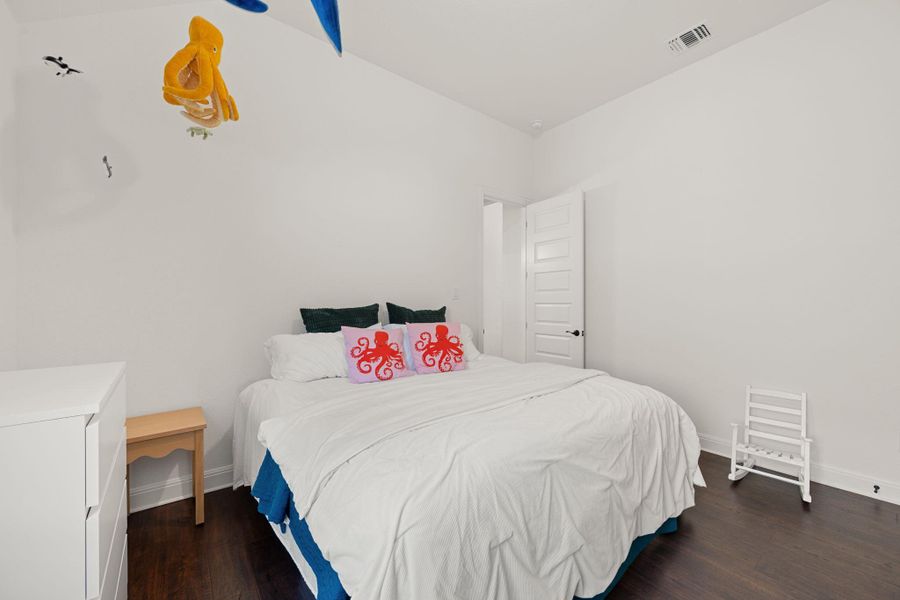 Hard surface floors and white walls create a serene and airy bedroom. Hard surface floors and white walls create a serene and airy bedroom.