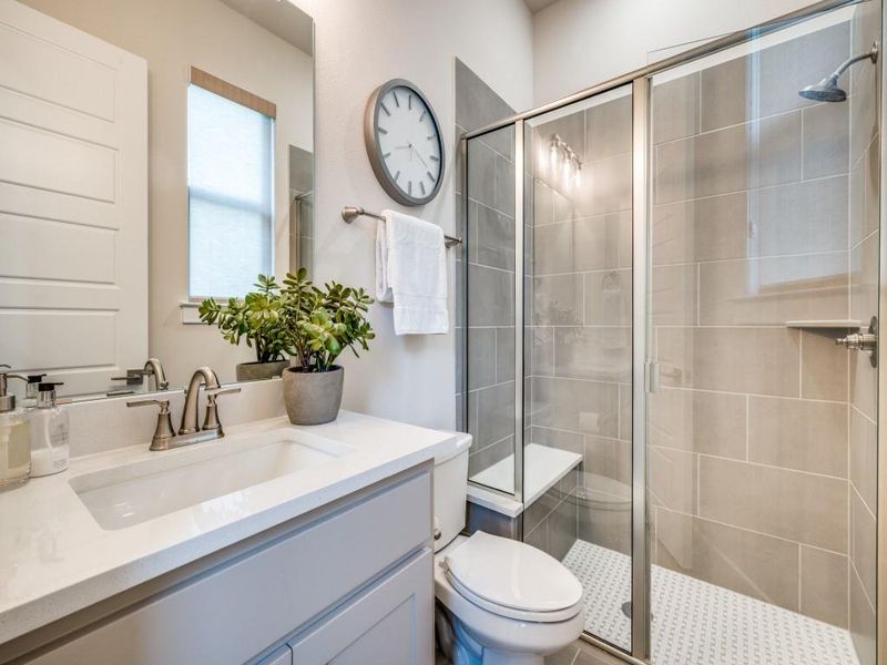 Bathroom with a shower stall, toilet, and vanity
