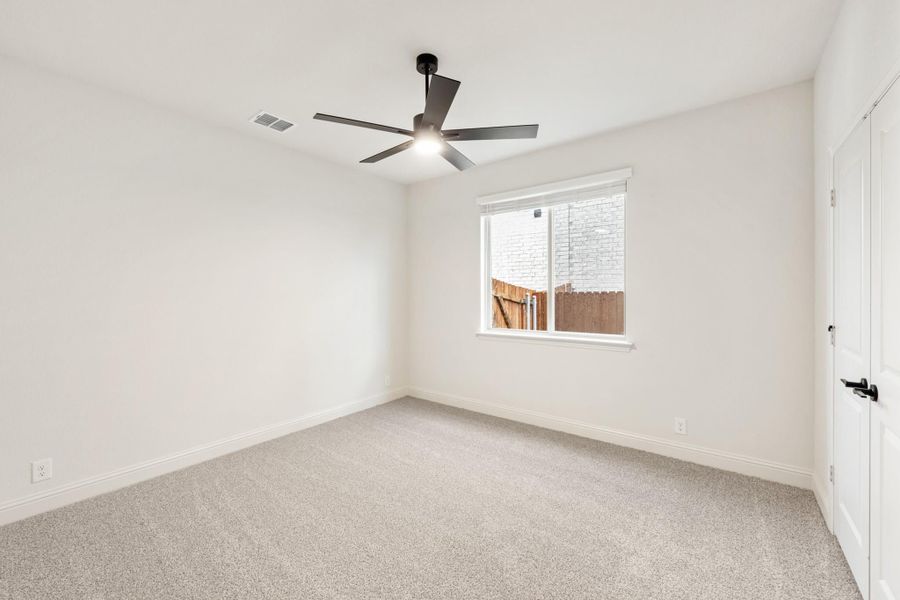 Empty bedroom with gray carpet, white walls, ceiling fan, and single window Empty bedroom with gray carpet, white walls, ceiling fan, and single window