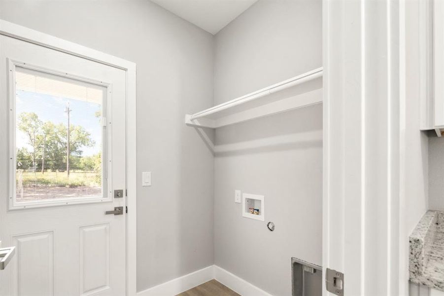 Laundry area featuring hookup for a washing machine and wood finished floors Laundry area featuring hookup for a washing machine and wood finished floors