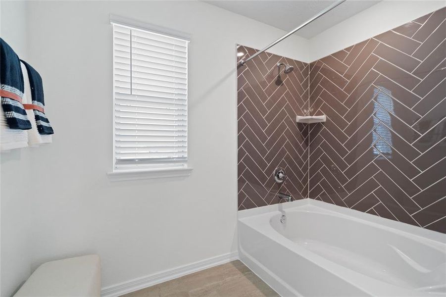 This primary bathroom is spectacular. The oversized tub/shower combination features gorgeous tile work, high ceilings, custom paint, sleek and dark modern finishes!