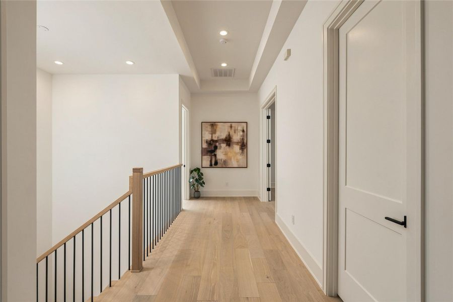 The second-floor landing continues the home’s clean architectural language, with 10-foot ceilings and an open stairwell creating an airy transition to the upper-level living spaces.