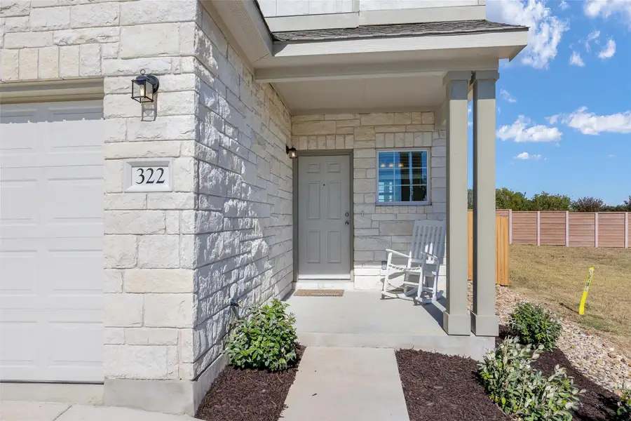 Entrance to property featuring stone siding and a garage Entrance to property featuring stone siding and a garage