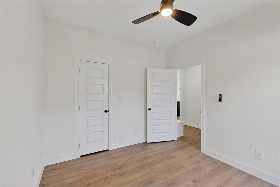 Unfurnished bedroom with light wood-style flooring and a ceiling fan Unfurnished bedroom with light wood-style flooring and a ceiling fan