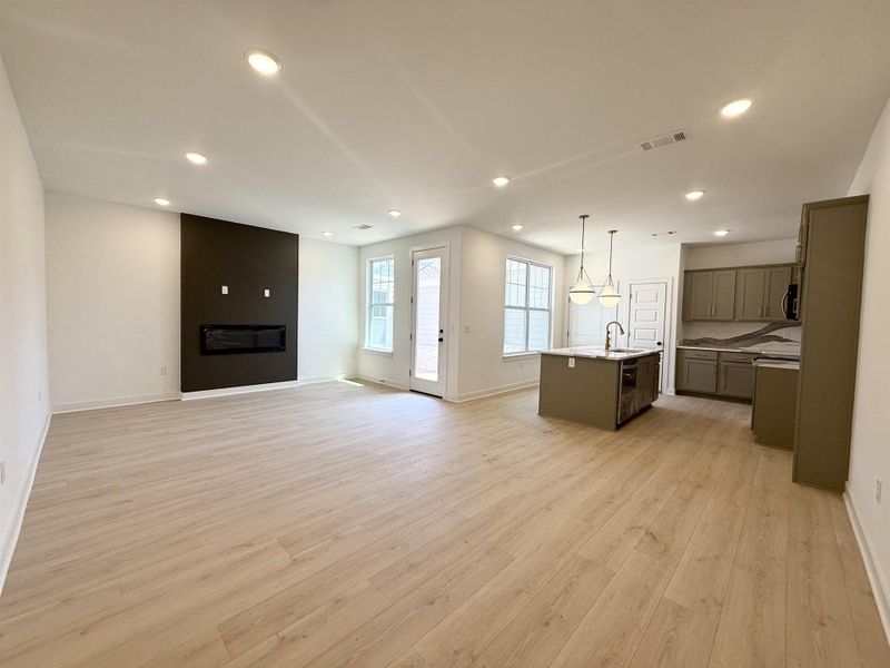 Unfurnished living room with light wood-style floors, recessed lighting, and a large fireplace