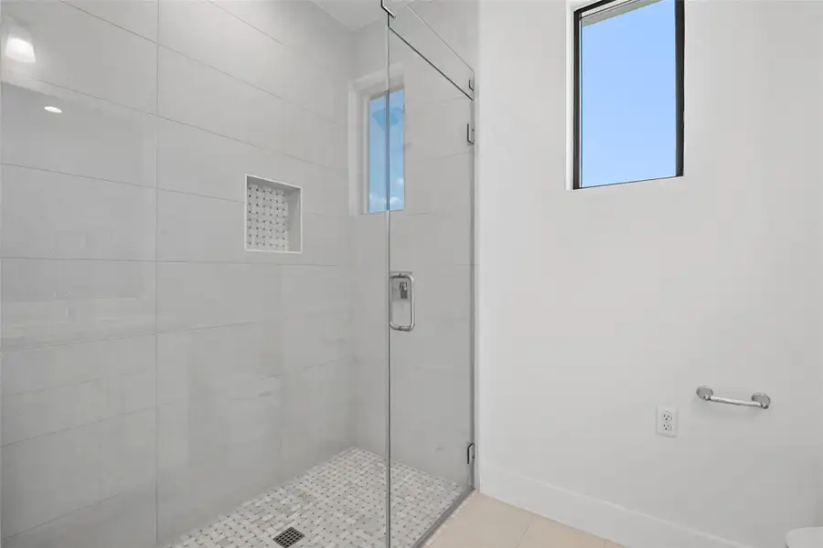 Full bath featuring a stall shower and light tile patterned floors