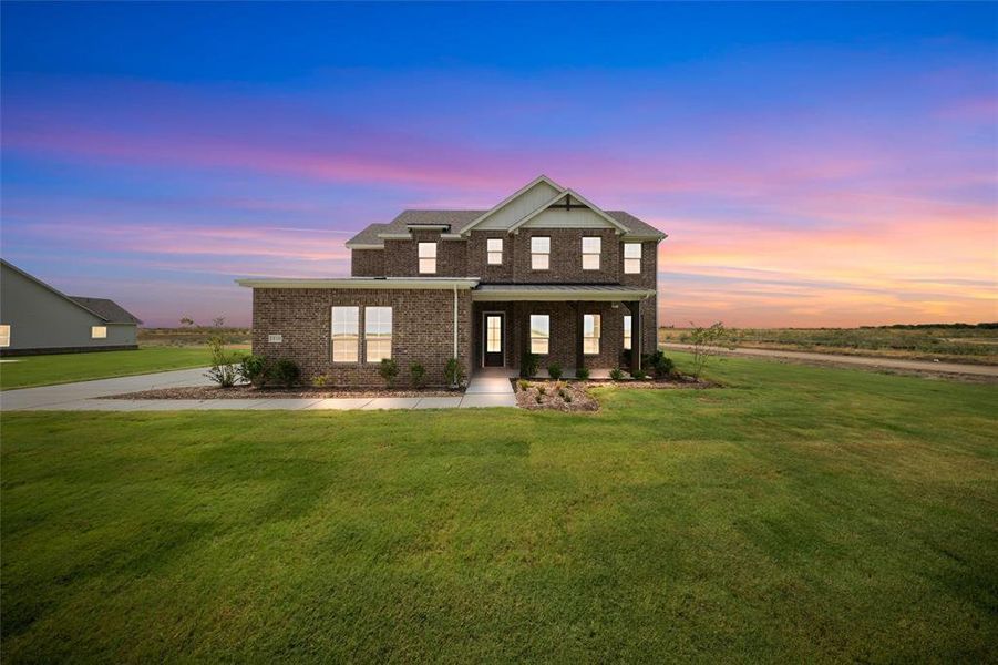 View of front of home with brick siding, covered porch, and a lawn View of front of home with brick siding, covered porch, and a lawn
