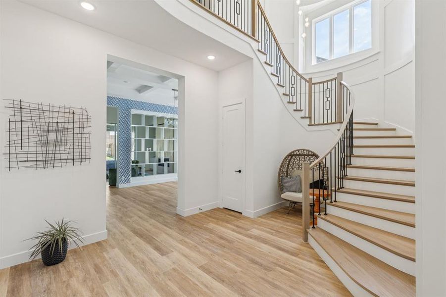 Entryway featuring plenty of natural light, wood finished floors, stairs, and recessed lighting
