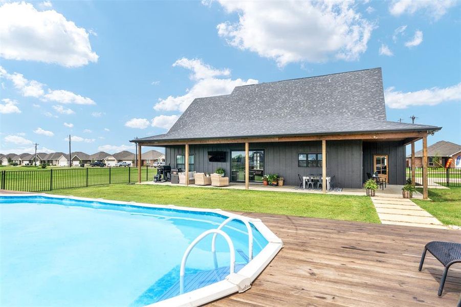 View of swimming pool featuring an outdoor living space, a fenced backyard, a wooden deck, and a residential view