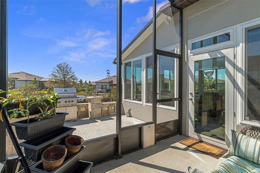 enclosed lanai with view of grilling patio