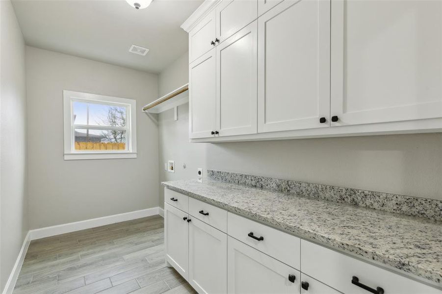 Laundry room featuring cabinets, washer hookup, light wood-type flooring, and electric dryer hookup