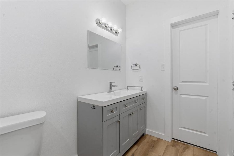 Bathroom with light wood-style flooring and vanity Bathroom with light wood-style flooring and vanity