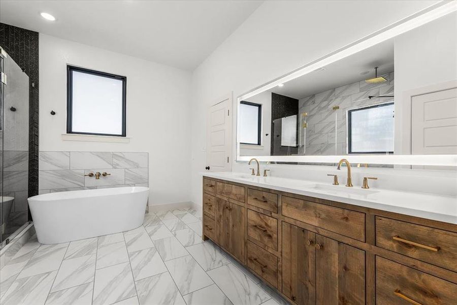 Gorgeous inset stained vanity with quartz countertops, gold finishes and oversized, backlit mirror.  Soaking tub with wall mounted faucet and large window with privacy glass.