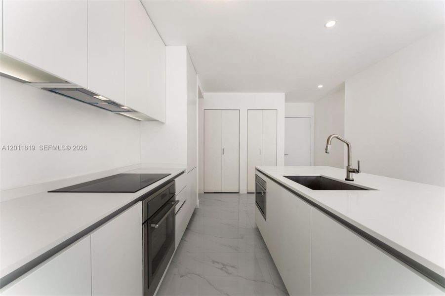 Modern chef’s kitchen equipped with custom Italian cabinetry, premium Miele appliances, integrated stone countertops, and a waterfall island perfect for entertaining.