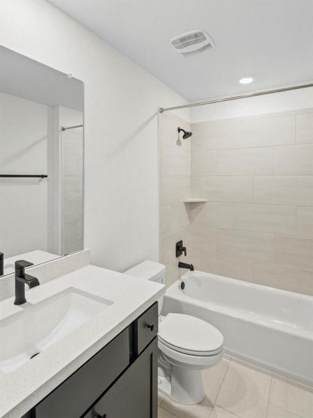 A well-appointed bathroom features a sleek vanity, modern fixtures, and tiled shower/tub combo. A well-appointed bathroom features a sleek vanity, modern fixtures, and tiled shower/tub combo.